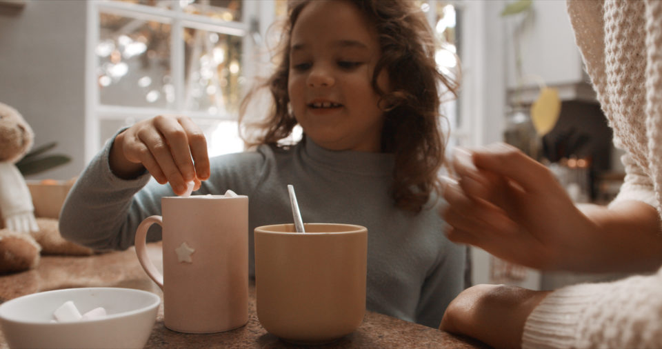 Cropped shot of a little girl and her mother having hot chocolate at home