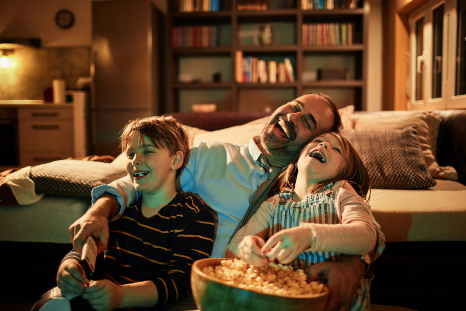 Close up of a father watching a movie with his kids