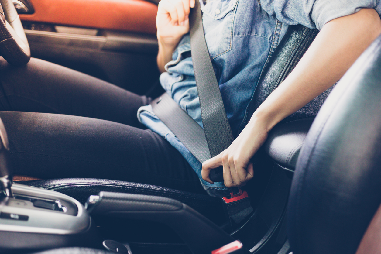 woman fastening seat belt in the car