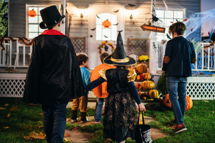 Young kids trick or treating at night during Halloween