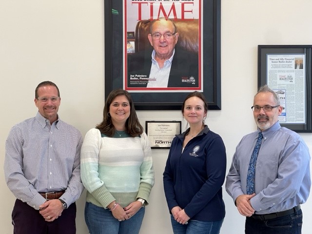 people surrounding framed Time Magazine cover