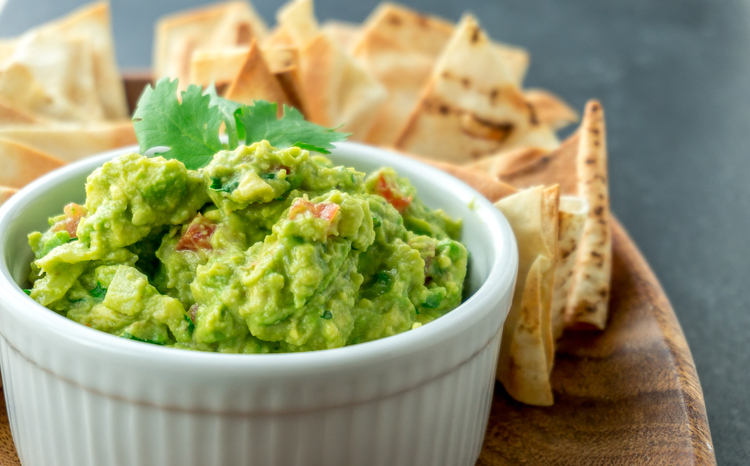 Guacamole close-up view. Guacamole is a avocado based dip, traditionally a mexican (Aztecs) dish. Healthy and easy to make at home with a few simple ingredients. Excellent as party food or at bars..