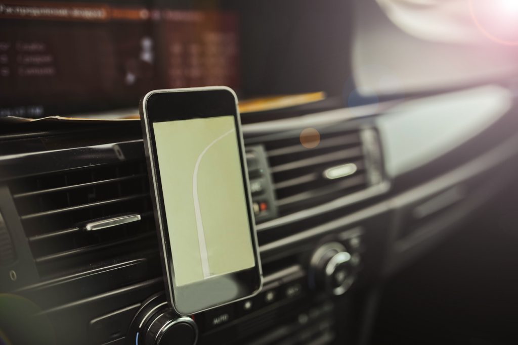 Phone mounted in a car, displaying a navigation map.